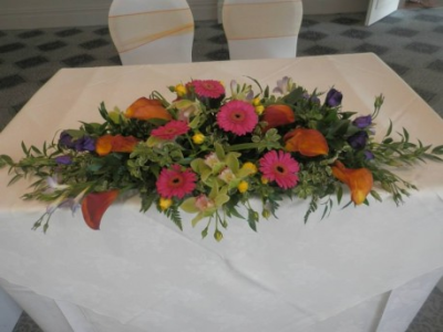 Top table flower display - A top table display with gerbras, lisianthus, greenery and cala lilies .Flowers and colours can be choosen to suit your needs
